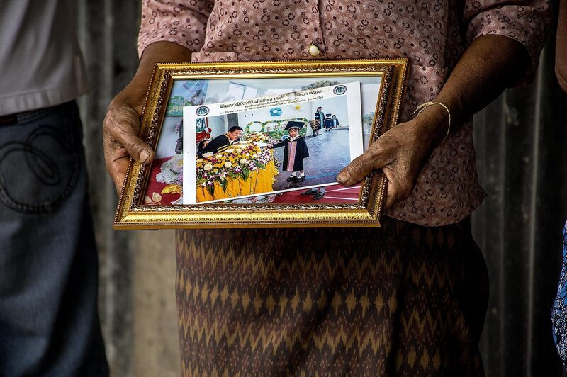 Elderly hands holding graduation photo frame