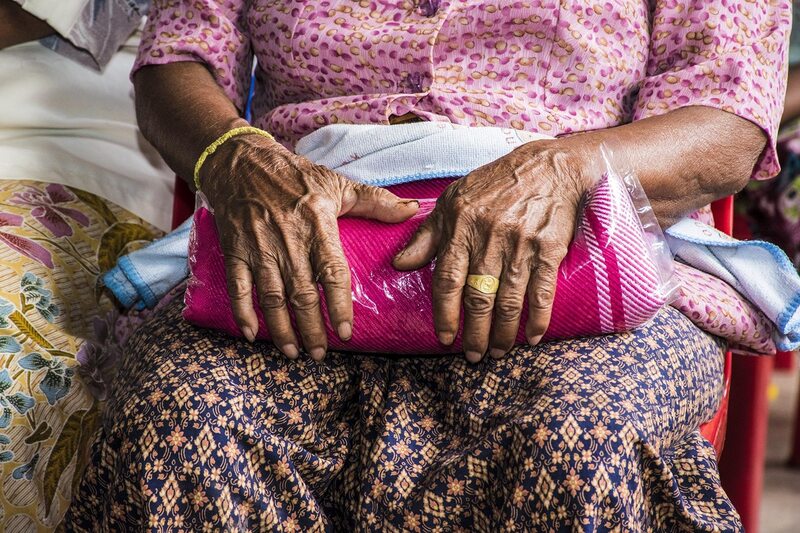 Elderly hands resting on lap