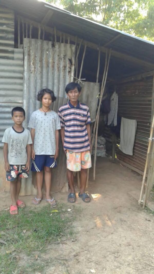 Nong Baem and Nong Boy standing by their home