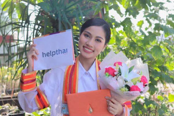 Nong Ni at graduation holding Help Thai sign